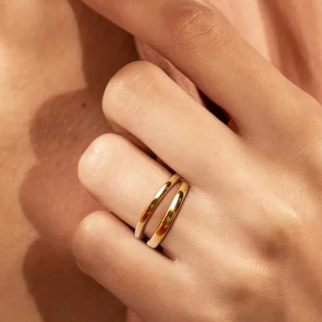 Gold ring on a person's finger with a soft focus background