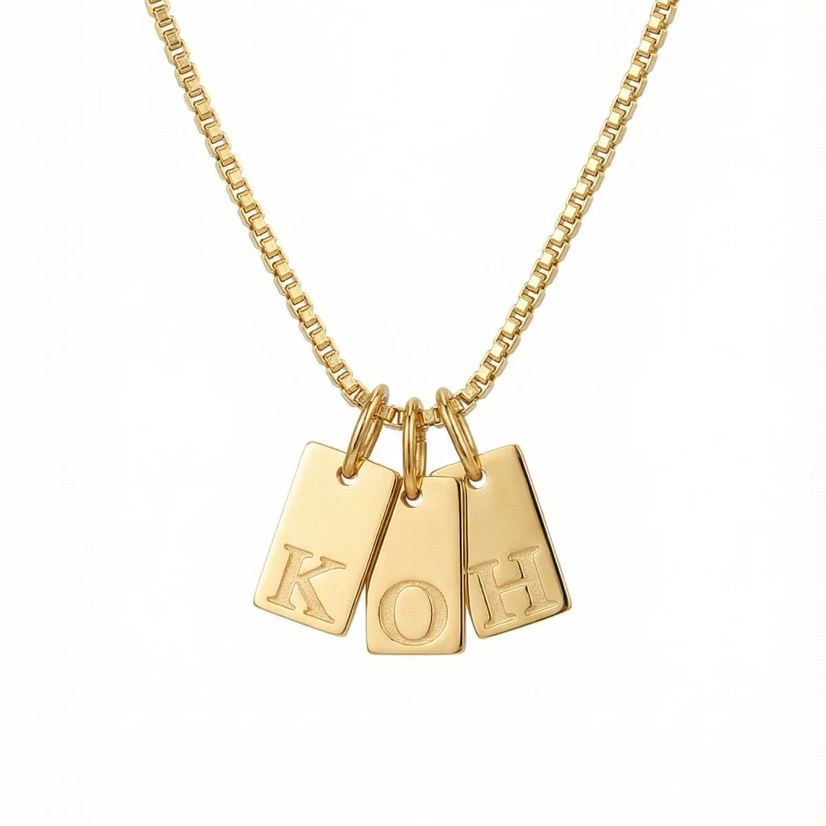 Gold necklace with three hanging pendant tags on a white background